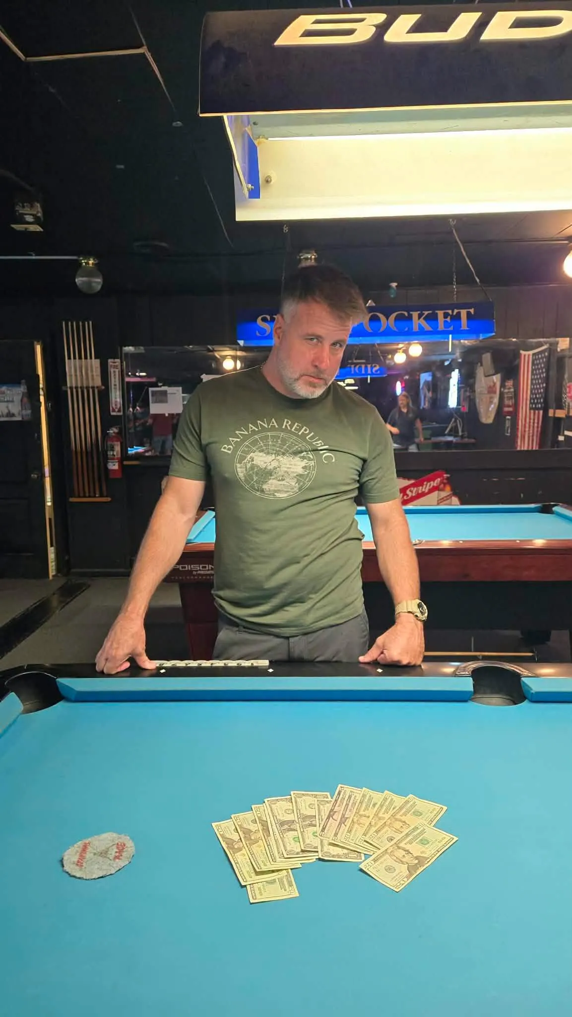 Tournament winner standing over his cash winnings on the table